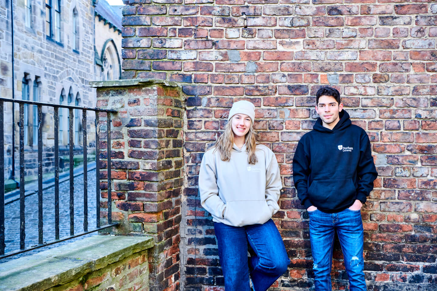 Two students wearing premium hoodies and almond beanie smiling