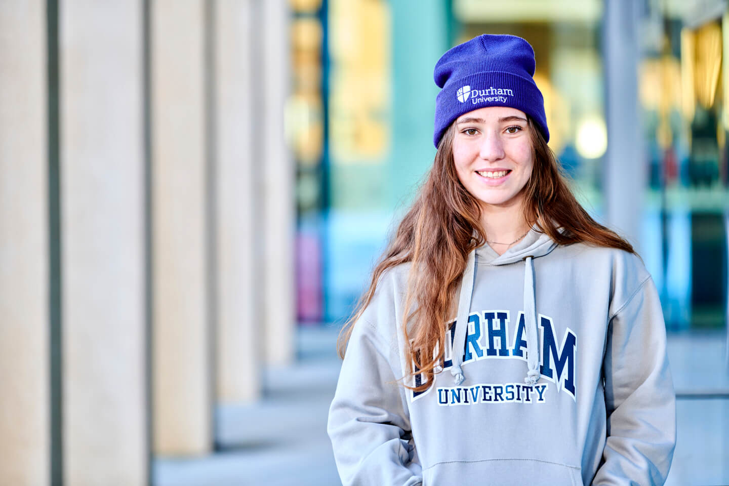 Student wearing Durham University Grey Hoody with Purple Beanie