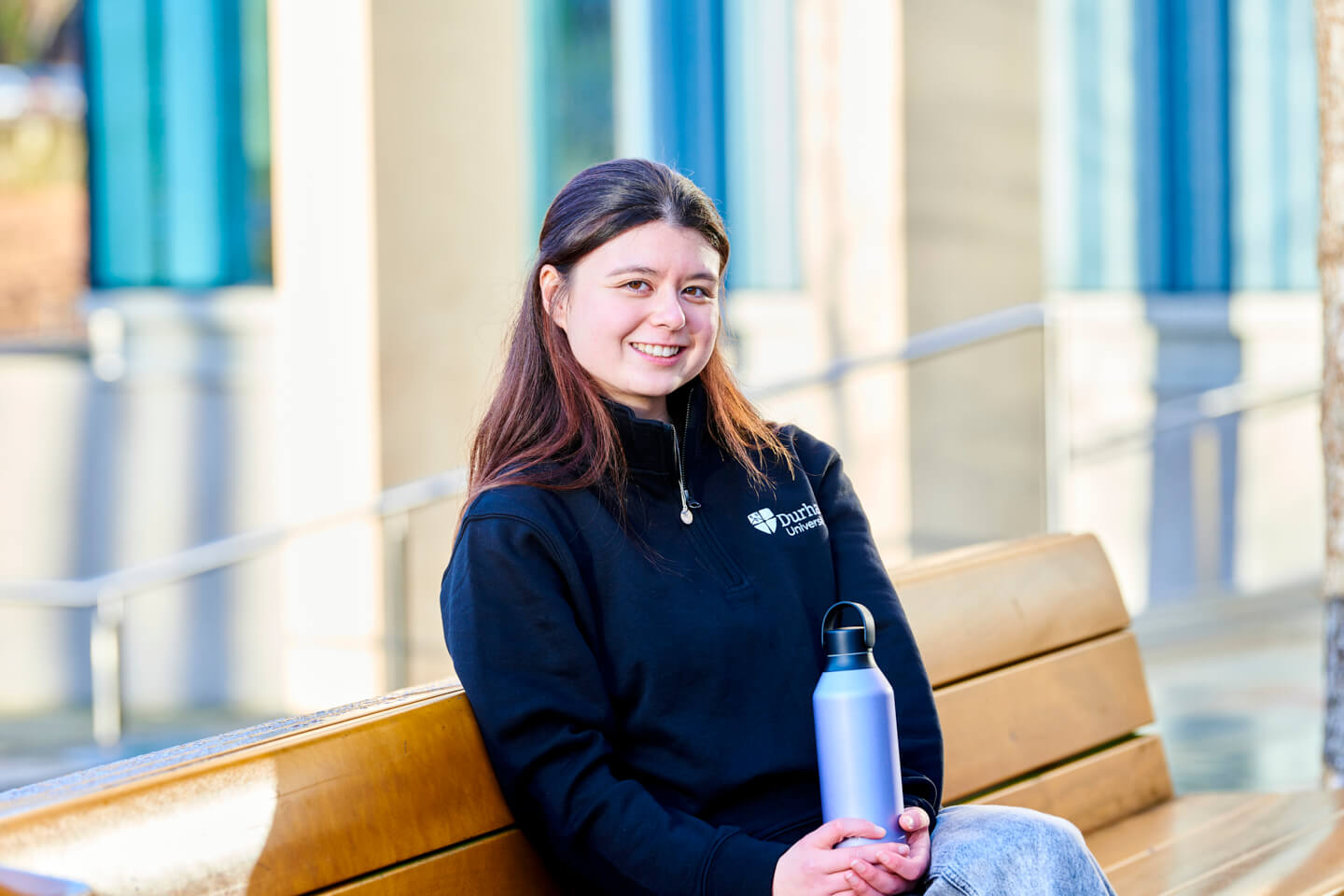 Student wearing black 1/4 zip and holding chilly's bottle