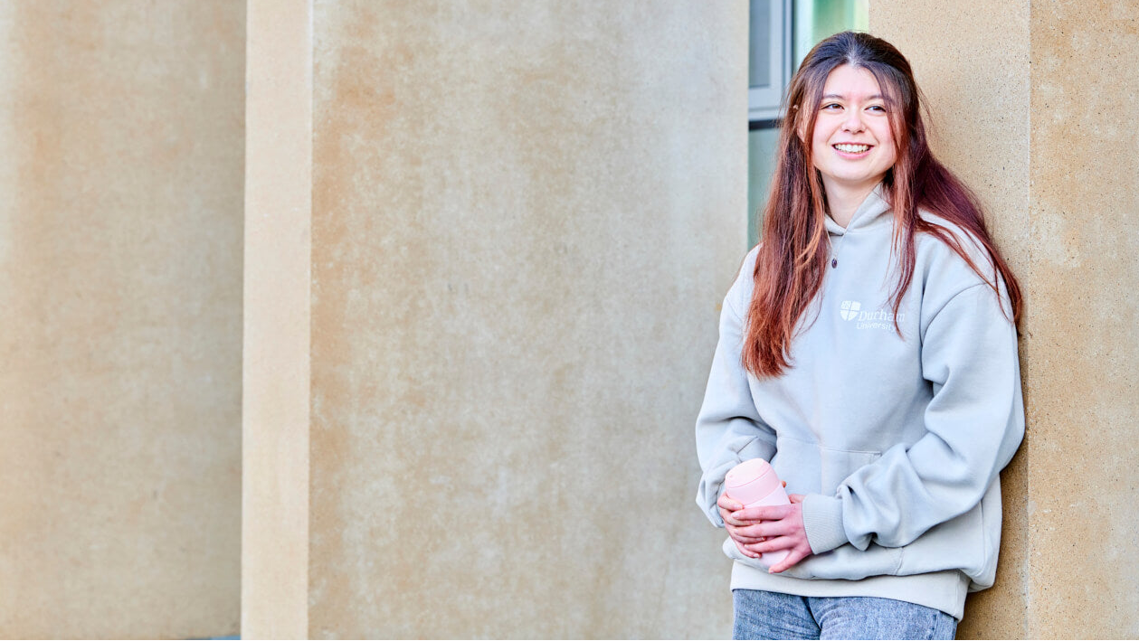 Student wearing stone hoody and holding chilly's cup
